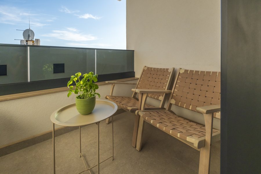 The balcony off the living room and kitchen, with two chairs and a small table
