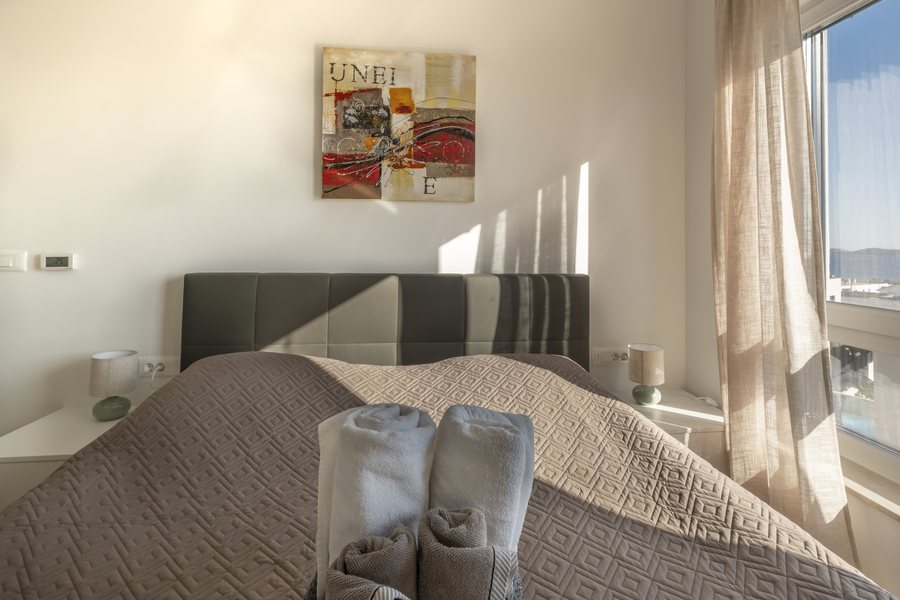 The double bed in bedroom 2, with towels laid out