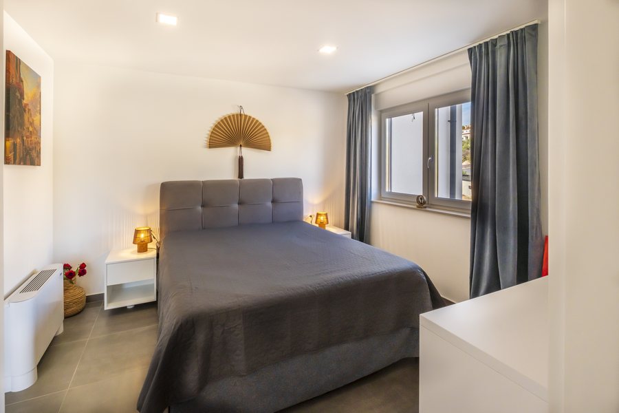 The bed in bedroom 3, with bedside lamps