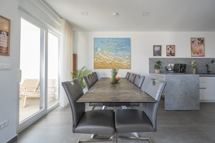 The long dining table, with the kitchen behind it