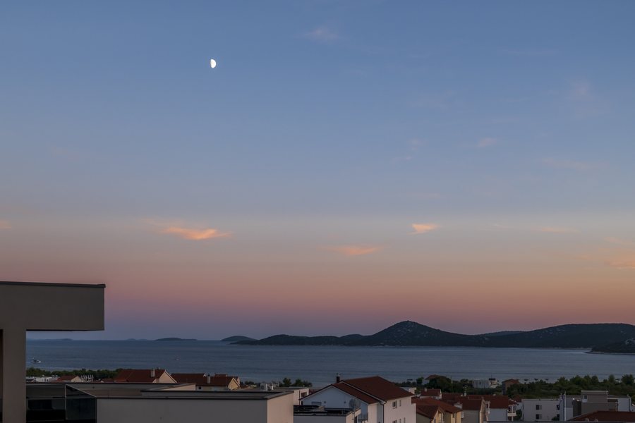 The sea and the islands at dusk, with the moon in the sky — the view from the bedrooms