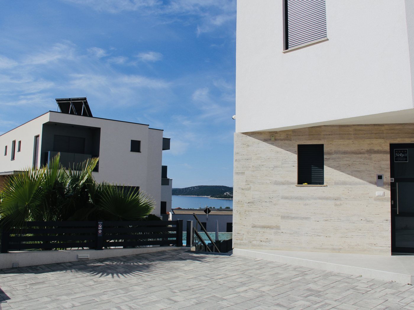 Villa NeRu s ulice, s morem u pozadini