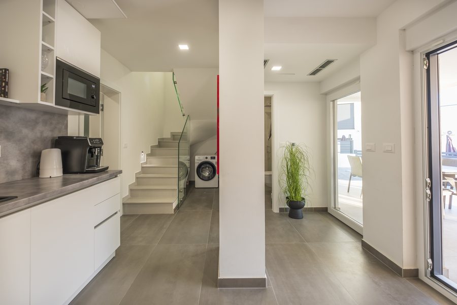 The second kitchen, with the stairs and washing machine beyond