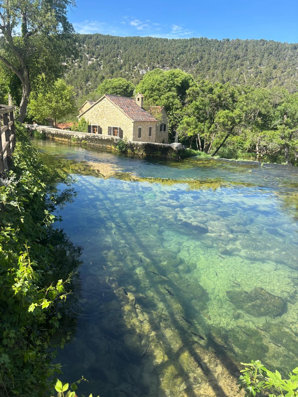 Kamena kuća na bistroj zelenoj rijeci Krki
