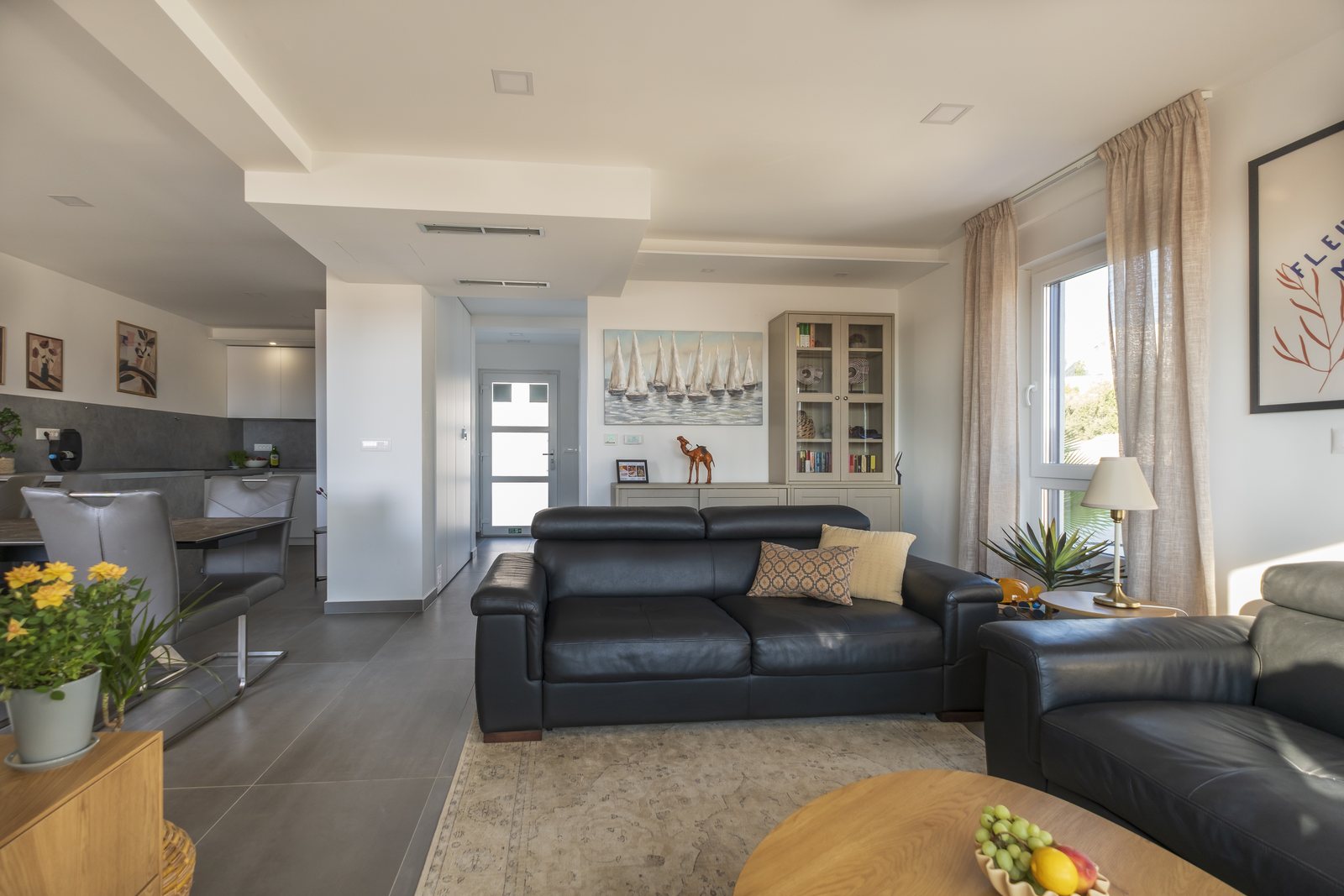 The living room, with the dining table and kitchen behind