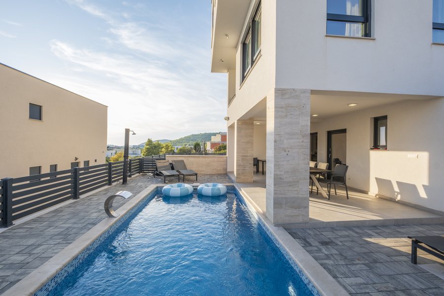 The pool and sun loungers in the afternoon light