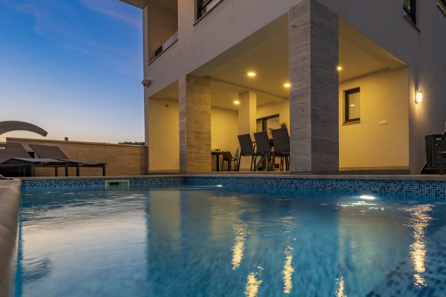 Evening by the pool, with the terrace lit