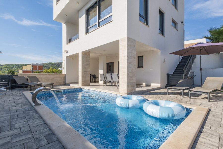 The pool with its water feature and sun loungers