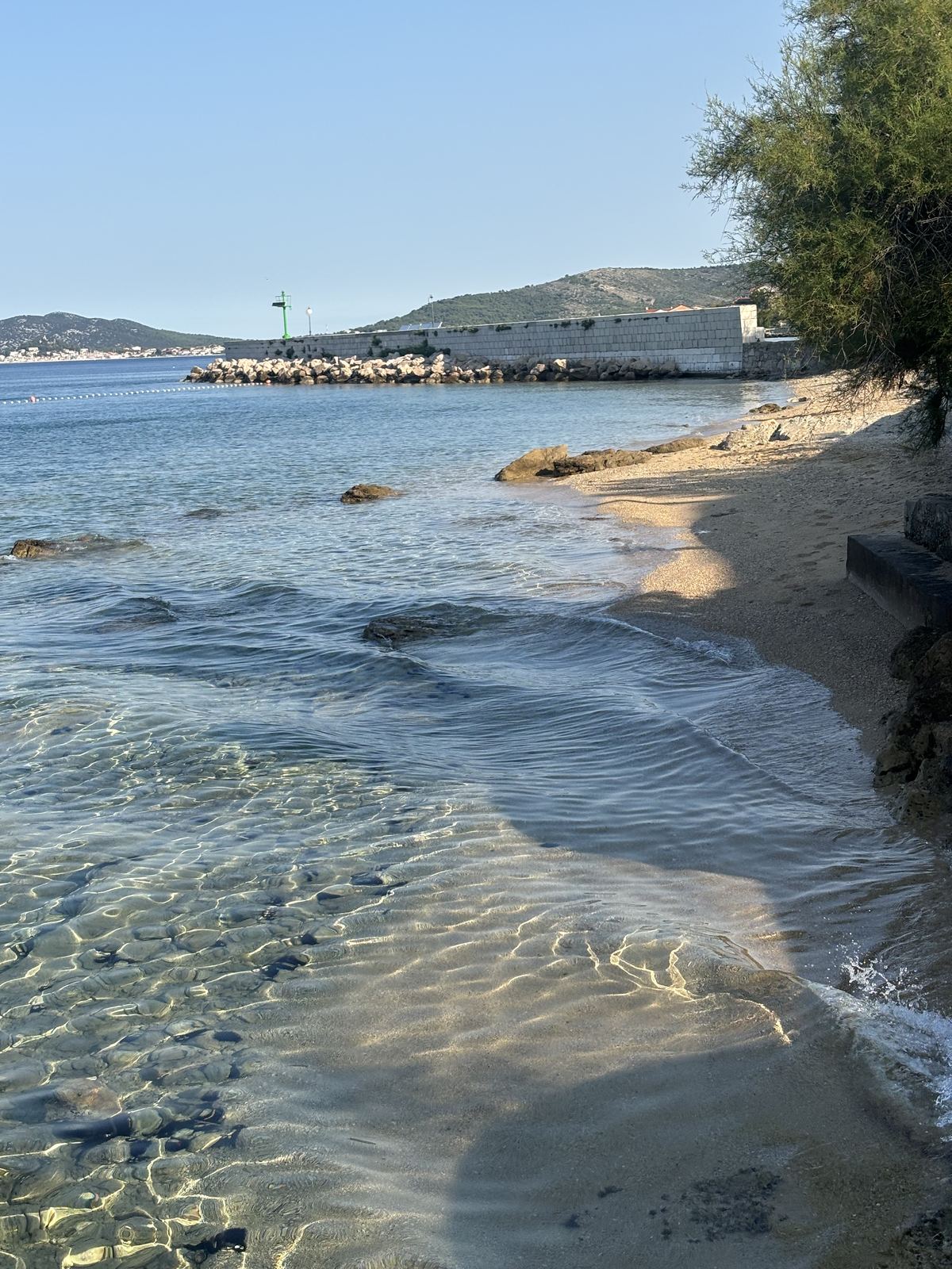 Sekély, tiszta öböl Prvićen, homokos parttal