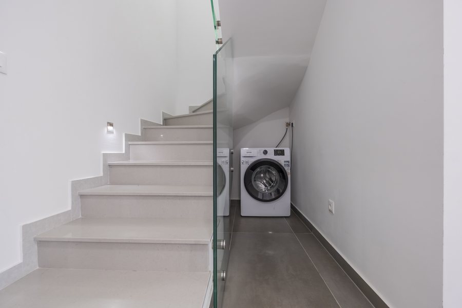 The stairs, with the washing machine tucked underneath