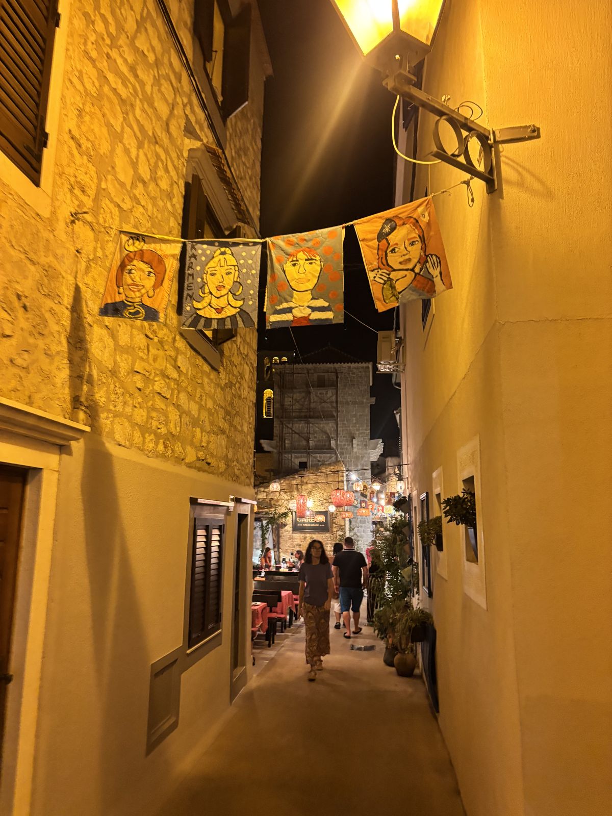 Eine Gasse in Vodice nach Einbruch der Dunkelheit, warmes Licht auf dem Stein
