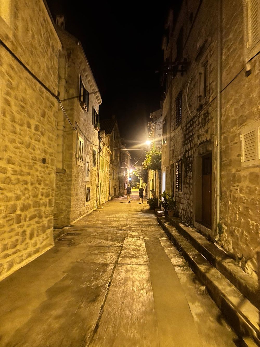 Eine schmale Gasse zwischen alten Steinhäusern am Abend