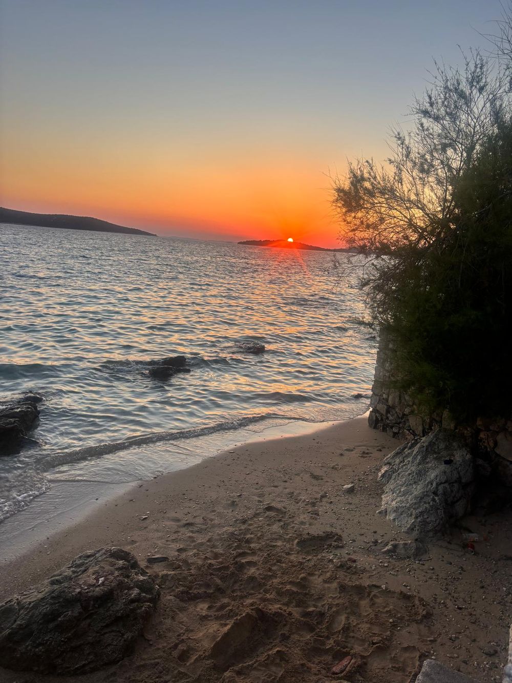 Sonnenuntergang über dem Meer, vom Kiesstrand aus